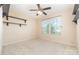 Bright bedroom featuring neutral carpet, a ceiling fan, natural light, and built-in shelving for storage or decor at 523 Smokehouse Ln, Albemarle, NC 28001