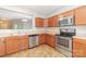 Bright kitchen features stainless steel appliances, tile flooring, and wood cabinetry at 523 Smokehouse Ln, Albemarle, NC 28001