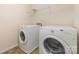 Laundry room with washer, dryer, and shelving for convenient storage at 523 Smokehouse Ln, Albemarle, NC 28001