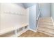 Mudroom features a coat rack with bench and cubbies leading to the carpeted staircase at 523 Smokehouse Ln, Albemarle, NC 28001