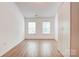 Bright bedroom featuring wood-look flooring, large windows, and a spacious built-in closet at 5319 Swearngan Rd, Charlotte, NC 28216
