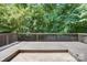 A wooden deck with a wooden railing overlooks a lush green wooded area at 5319 Swearngan Rd, Charlotte, NC 28216