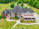 Stunning aerial view of a luxurious brick home with manicured landscaping, large driveway, and inviting outdoor spaces at 572 W Shiloh Unity Rd, Lancaster, SC 29720