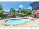 Beautiful backyard featuring an in-ground pool, outdoor kitchen, palm trees, and comfortable lounge area for entertaining at 572 W Shiloh Unity Rd, Lancaster, SC 29720