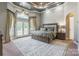 Luxurious main bedroom with tray ceiling, plush carpet, french doors, and elegant window treatments at 572 W Shiloh Unity Rd, Lancaster, SC 29720