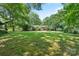 A large grassy backyard provides ample space for recreation and relaxation, complete with mature trees and landscaping at 5914 Mt Holly Huntersville Rd, Charlotte, NC 28216