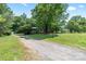 A long driveway leads to a home surrounded by mature trees, creating a private and picturesque setting at 5914 Mt Holly Huntersville Rd, Charlotte, NC 28216