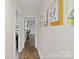 Hallway with hardwood floors and decorative artwork on the wall leading to the kitchen at 5914 Mt Holly Huntersville Rd, Charlotte, NC 28216
