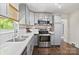 Well-lit kitchen featuring stainless steel appliances, gray cabinets and elegant subway tile backsplash at 5914 Mt Holly Huntersville Rd, Charlotte, NC 28216