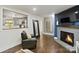 Cozy living room with hardwood floors, fireplace, and a peek into the adjacent kitchen area at 5914 Mt Holly Huntersville Rd, Charlotte, NC 28216