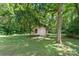 A charming wooden shed sits nestled among mature trees in a serene and private backyard setting at 5914 Mt Holly Huntersville Rd, Charlotte, NC 28216