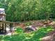 Expansive backyard featuring lush greenery and mature trees, complemented by a covered patio at 5955 Mountain Point Ln, Charlotte, NC 28216