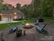Backyard with a fire pit area, gravel, chairs and an expansive lawn at 5955 Mountain Point Ln, Charlotte, NC 28216