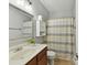 Clean bathroom with a wood vanity, framed mirror, toilet, and shower with striped curtain at 5955 Mountain Point Ln, Charlotte, NC 28216