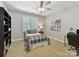 Neutral bedroom with a plaid coverlet, office space, and ample natural light at 5955 Mountain Point Ln, Charlotte, NC 28216