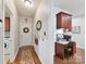 Welcoming hallway leading to a desk nook featuring wood accents and a decorative wreath on the entry door at 5955 Mountain Point Ln, Charlotte, NC 28216