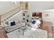 Spacious living room with staircase, kitchen view, hardwood floors, natural light, and modern neutral furnishings at 5955 Mountain Point Ln, Charlotte, NC 28216