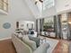 Sunlit living room with hardwood floors, fireplace, modern furnishings, and large windows offering scenic views at 5955 Mountain Point Ln, Charlotte, NC 28216