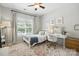 Cozy bedroom features a ceiling fan, neutral walls, and a window overlooking the backyard at 606 Vega Nw St, Concord, NC 28027
