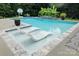 Beautiful swimming pool with in-pool lounge chairs, lush landscaping, and a serene atmosphere at 606 Vega Nw St, Concord, NC 28027