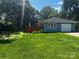 Spacious backyard with lush green grass and mature trees providing plenty of shade at 6109 Cora St, Charlotte, NC 28216