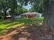Large backyard with a deck perfect for outdoor entertaining, lush grass, and shady trees at 6109 Cora St, Charlotte, NC 28216
