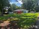 Expansive backyard featuring a deck, mature trees, and plenty of green space at 6109 Cora St, Charlotte, NC 28216