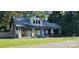 Home with damaged facade, covered front porch, and trees in the background at 619 N Main St, Landis, NC 28088