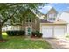 Charming two-story home featuring a stone facade, well-manicured lawn, and attached two-car garage at 6619 Bittinger Ct, Charlotte, NC 28216