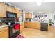 Cozy kitchen featuring light wood cabinets, black appliances, and open access to the dining area at 6619 Bittinger Ct, Charlotte, NC 28216
