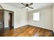 Bedroom with hardwood floors, neutral walls, and a ceiling fan; door leads to closet/bath at 814 Grace St, Kings Mountain, NC 28086