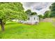 Lush green lawn surrounds the side of the house with its well-kept white siding and mature trees at 814 Grace St, Kings Mountain, NC 28086
