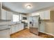 Updated kitchen showcasing stainless steel appliances, white cabinets, and tiled backsplash at 814 Grace St, Kings Mountain, NC 28086