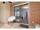 Covered patio with brick floor, seating, and sliding door to interior at 825 21St Ne Ave, Hickory, NC 28601
