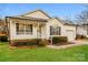 Charming single-story home with white siding, a well-manicured lawn, and an attached single-car garage at 828 Saint Andrews Pl, Concord, NC 28025