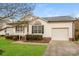 Charming single-story home with white siding, a well-manicured lawn, and an attached single-car garage at 828 Saint Andrews Pl, Concord, NC 28025