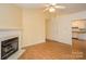 Cozy living room featuring a fireplace, wood floors, and neutral-colored walls that lead into the kitchen at 828 Saint Andrews Pl, Concord, NC 28025