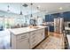 Bright kitchen features an island with white countertops, stainless appliances, and pendant lighting at 8516 Profit Ln, Charlotte, NC 28215