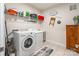 Functional laundry room with modern washer and dryer, complete with shelving for efficient storage and organization at 8516 Profit Ln, Charlotte, NC 28215