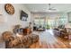 Bright living room with wood floors, ceiling fan, and access to a screened porch at 8516 Profit Ln, Charlotte, NC 28215