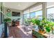 Sunroom with many plants, hardwood floors, and large windows, creating a serene space with natural light and greenery at 8516 Profit Ln, Charlotte, NC 28215
