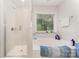 Bright bathroom featuring soaking tub with window and glass shower at 9807 Maywine Cir, Huntersville, NC 28078
