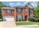 Charming two-story brick home featuring a manicured lawn, attached garage, and classic architectural details at 9807 Maywine Cir, Huntersville, NC 28078