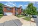 Beautiful brick home with a well-maintained lawn, mature trees, and a spacious driveway at 9807 Maywine Cir, Huntersville, NC 28078