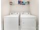 Bright laundry room featuring a white washer and dryer with shelving at 9807 Maywine Cir, Huntersville, NC 28078