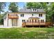 Rear view of a beautiful two story white brick home with wood decks and a lawn at 9830 Spring Harvest Dr, Mint Hill, NC 28227