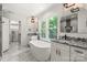 A modern bathroom with double sinks, standalone tub, and stylish fixtures for luxury living at 9830 Spring Harvest Dr, Mint Hill, NC 28227