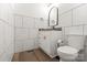 Bathroom featuring white tile walls, a marble vanity top, and a modern toilet at 9830 Spring Harvest Dr, Mint Hill, NC 28227