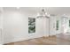 Dining room featuring a modern chandelier, white walls, and wood floors at 9830 Spring Harvest Dr, Mint Hill, NC 28227