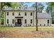 Charming two-story white brick home with a black roof, dormers, and landscaped front yard at 9830 Spring Harvest Dr, Mint Hill, NC 28227